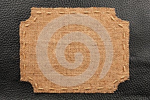 Frame of burlap, lies on a background of black leather