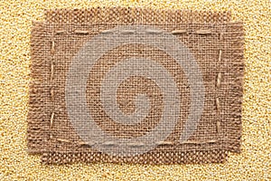 Frame of burlap lying on a millet background