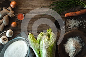 Frame with Chinese cabbage and ingredients for kimchi on a wooden table