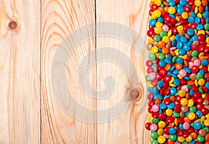 Frame of colorful candy on wood background