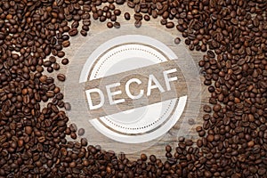 Frame of decaf coffee beans on wooden table, flat lay