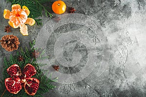 Frame of delicious garnet, mandarin. cinnamon and anise on dark background. Christmas of New year concept. Flat lay. Top view