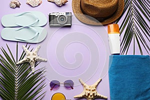 Frame of beach objects on violet background, flat lay. Space for text