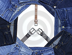 Frame of different blue jeans and leather belts isolated on white background top view flat lay. Detail of nice blue