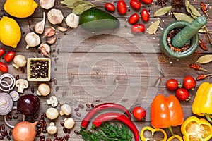 Frame of different fresh organic vegetables and spices on wooden table. Healthy natural food background with copy space.