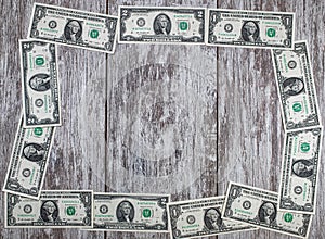 The frame of dollar bills is laid out on a wooden background