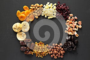Frame of dried fruits and nuts on a black background, top view. Overhead, from above, flat lay