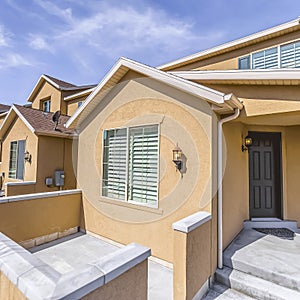 Frame Entrance to a house with concrete stairs leading to the brown front door