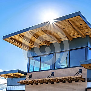 Frame Facade of building with flat roof and brick wall against blue sky on a sunny day