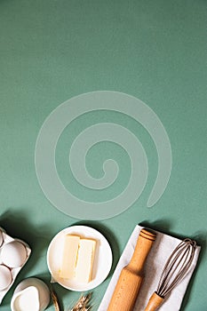 Frame of food ingredients for baking on a green pastel background. Cooking flat lay with copy space. Top view. Baking concept.