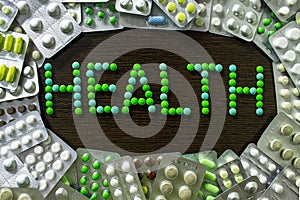 Frame, frames from pills spilling on a brown background with the words `Health`. Medical concept of drug treatment