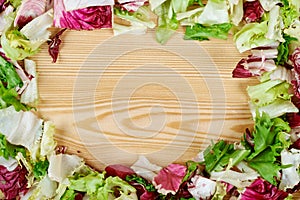 Frame of fresh green salad on wooden background. Healthy natural food . mockup for recipe or menu.