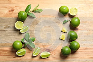 Frame of fresh ripe limes on wooden background