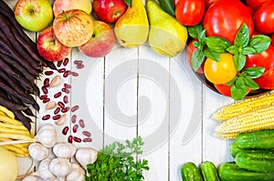 Frame of fresh vegetables and fruits on a white wooden table