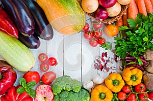 Frame of fresh vegetables and fruits on a white wooden table