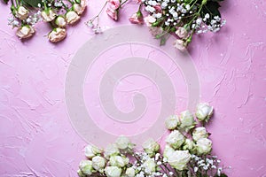 Frame from fresh white gypsofila and white rose flowers on pink textured background photo