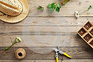 Frame of gardening tools and flowers on vintage wooden table. Gardening or planting concept. Working in the spring garden. Flat