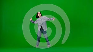 In the frame on a green background, a limp. Dances young, beautiful girl. Demonstrates dance moves in the style of hip