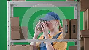 In the frame on a green background, a limp. Depicts a young woman in a uniform. Depicts an employee, in a warehouse. She