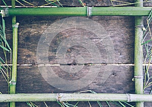 Frame from green bamboo on an old rustic wooden table.