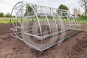 Frame of greenhouse is installed in garden