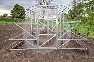 Frame of greenhouse is installed in garden