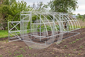 Frame of greenhouse is installed in garden