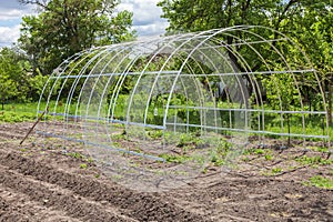 Frame of greenhouse is installed in garden