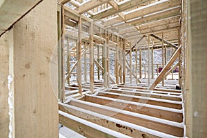 frame house construction in winter, under the snow, in the forest. Fresh wood, frame of a two-story house