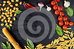 Frame of Italian traditional food, spices and ingredients for cooking as basil, cherry tomatoes, chili pepper, garlic and pasta