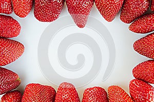 Frame of juicy strawberries on a white background. Frame with saved space.