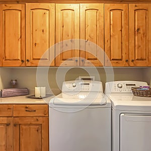 Frame Laundry room interior with washer dryer and counter against the beige wall