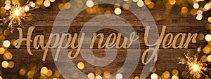 Frame of lights bokeh golden flares and sparkler isolated on rustic brown wooden texture - Holiday New Year`s Eve Silvester New