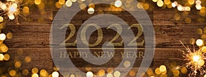 Frame of lights bokeh golden flares and sparkler isolated on rustic brown wooden texture - Holiday New Year`s Eve Silvester New