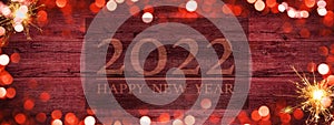 Frame of lights bokeh golden flares and sparkler isolated on rustic red wooden texture - Holiday New Year`s Eve Silvester New Yea