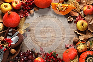 Frame made of autumn vegetables, fruits and cutlery on wooden background, space for text. Happy Thanksgiving day