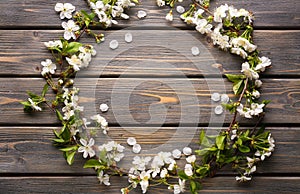 Frame made of beautiful blossoming branches on wooden background