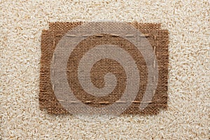 Frame made of burlap with the line lies on rice grains
