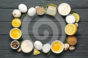 Frame made with fresh mayonnaise and ingredients on black wooden table, flat lay. Space for text