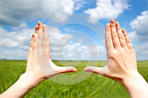 Frame made of hands at wheat field