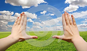 Frame made of hands at wheat green field