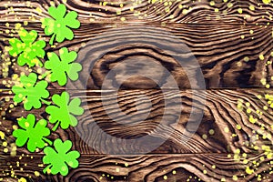 Frame made of light lights clover leaves. Wooden background with clover leaves. St. Patrick`s Day. Textured wood, preparation for