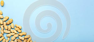 Frame made of nuts peanuts in shell with copy space on blue colored background. Flat lay with place for text for peanut butter,