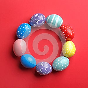 Frame made of painted Easter eggs on color background. Space for text