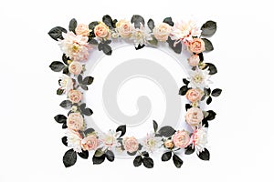 Frame made of pink roses, green leaves eucalyptus, branches, floral pattern on white background. Flat lay, top view