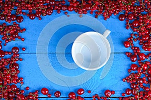 Frame made of red currant and cherry with empty coffee cup