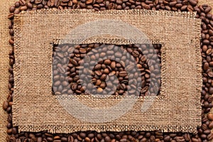 Frame made of rough burlap lies on coffee beans