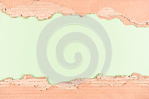 Frame made with sheets of corrugated cardboard over light green background as eco background with copy space
