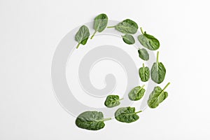 Frame made of spinach leaves on white background, top view.