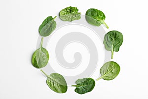 Frame made of spinach leaves on white background, top view